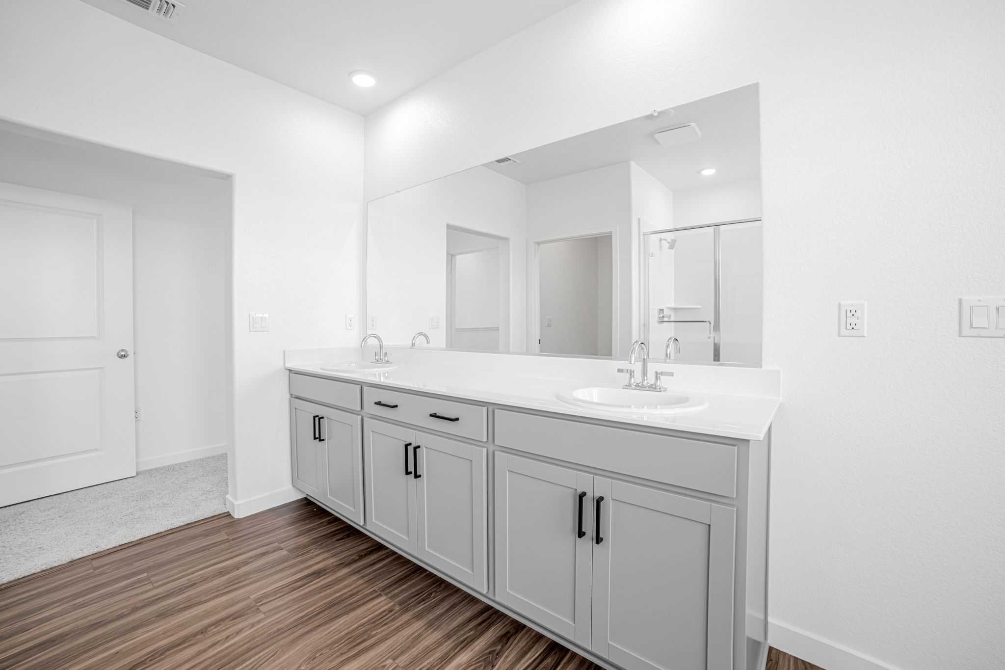 A bathroom with white cabinets.
