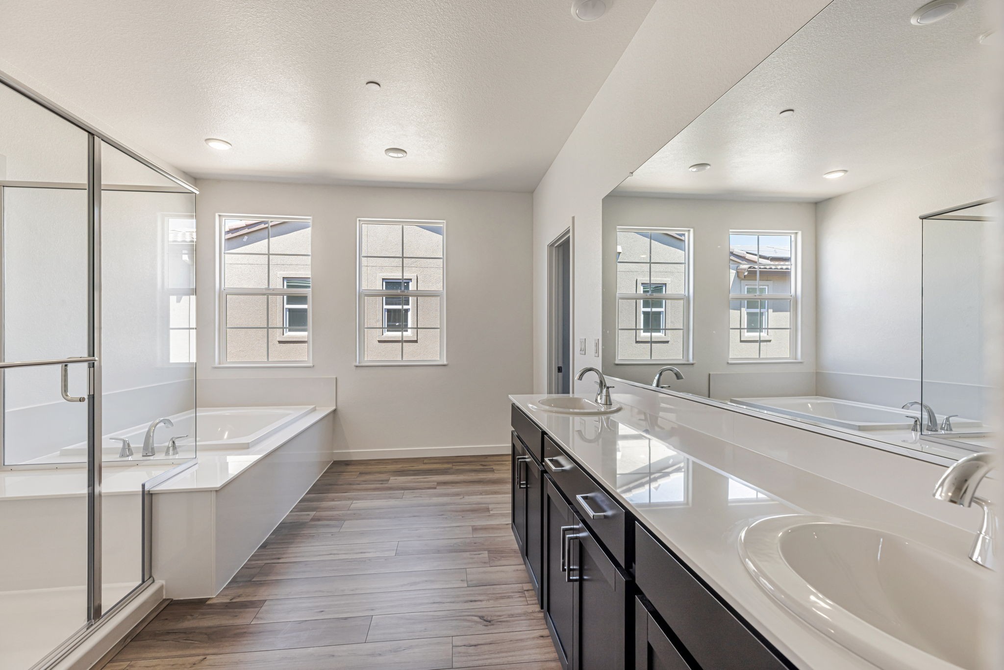 A bathroom with a large tub and sinks.
