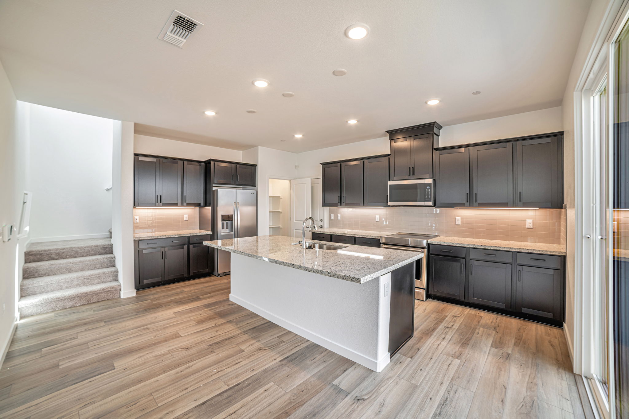 A kitchen with black cabinets.