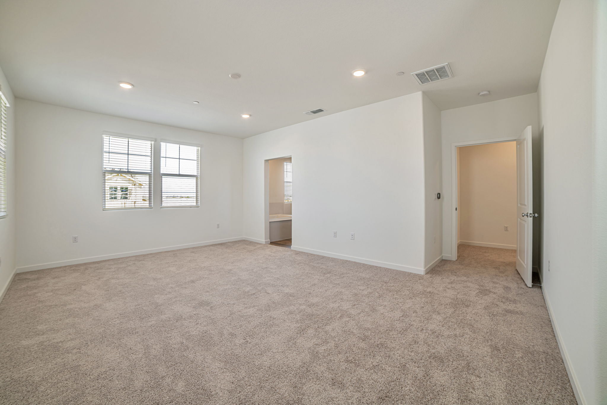 A room with a carpet and a door.