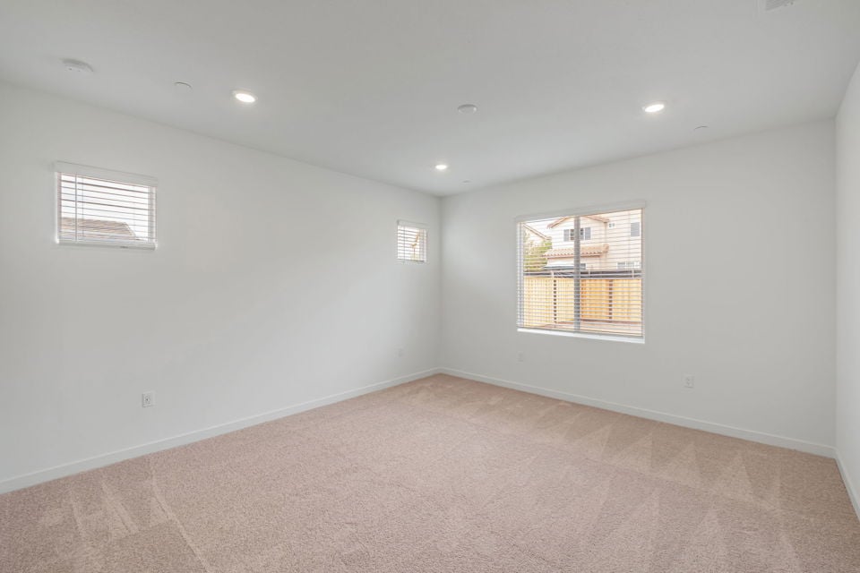 A room with a carpet and windows.