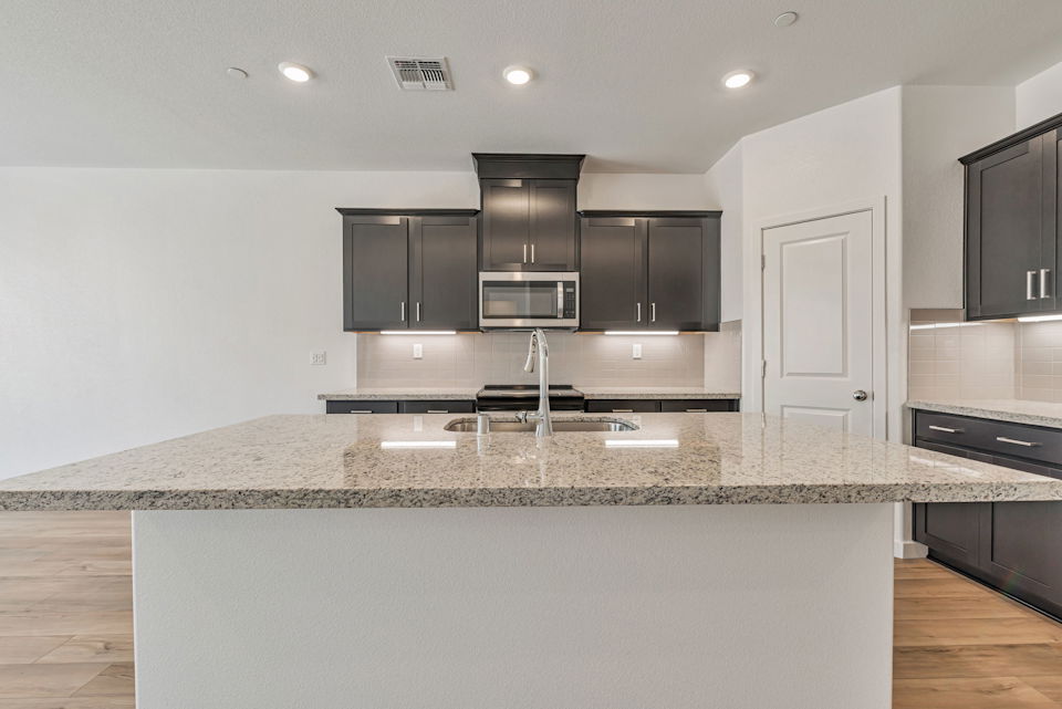A kitchen with black cabinets.
