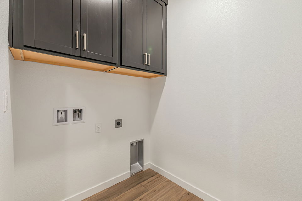 A room with a wood floor and cabinets.