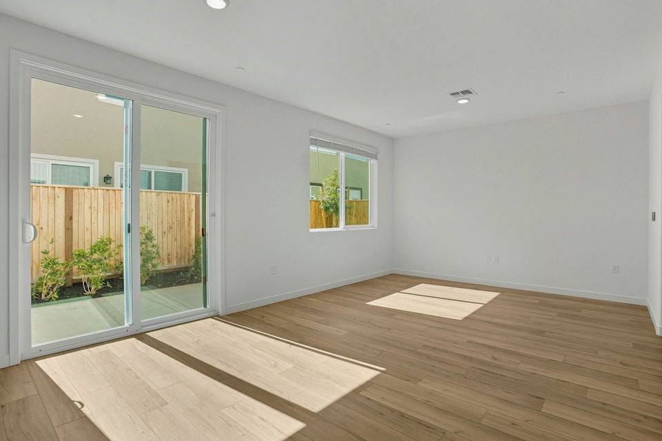 A room with a wood floor and a wood floor with a window.