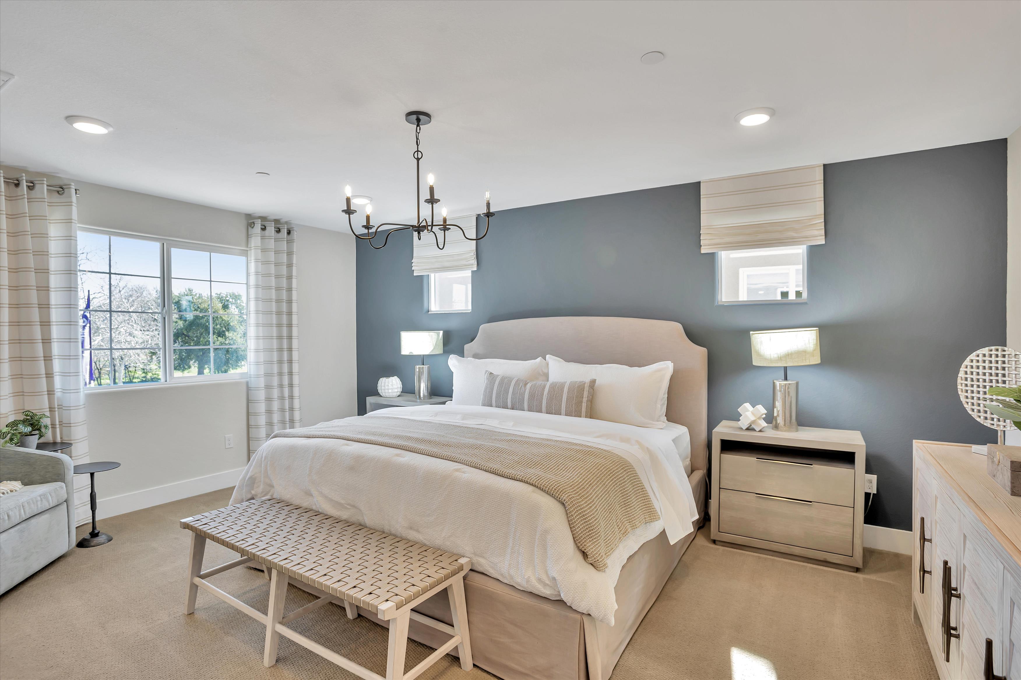 A bedroom with a bed and a bench.