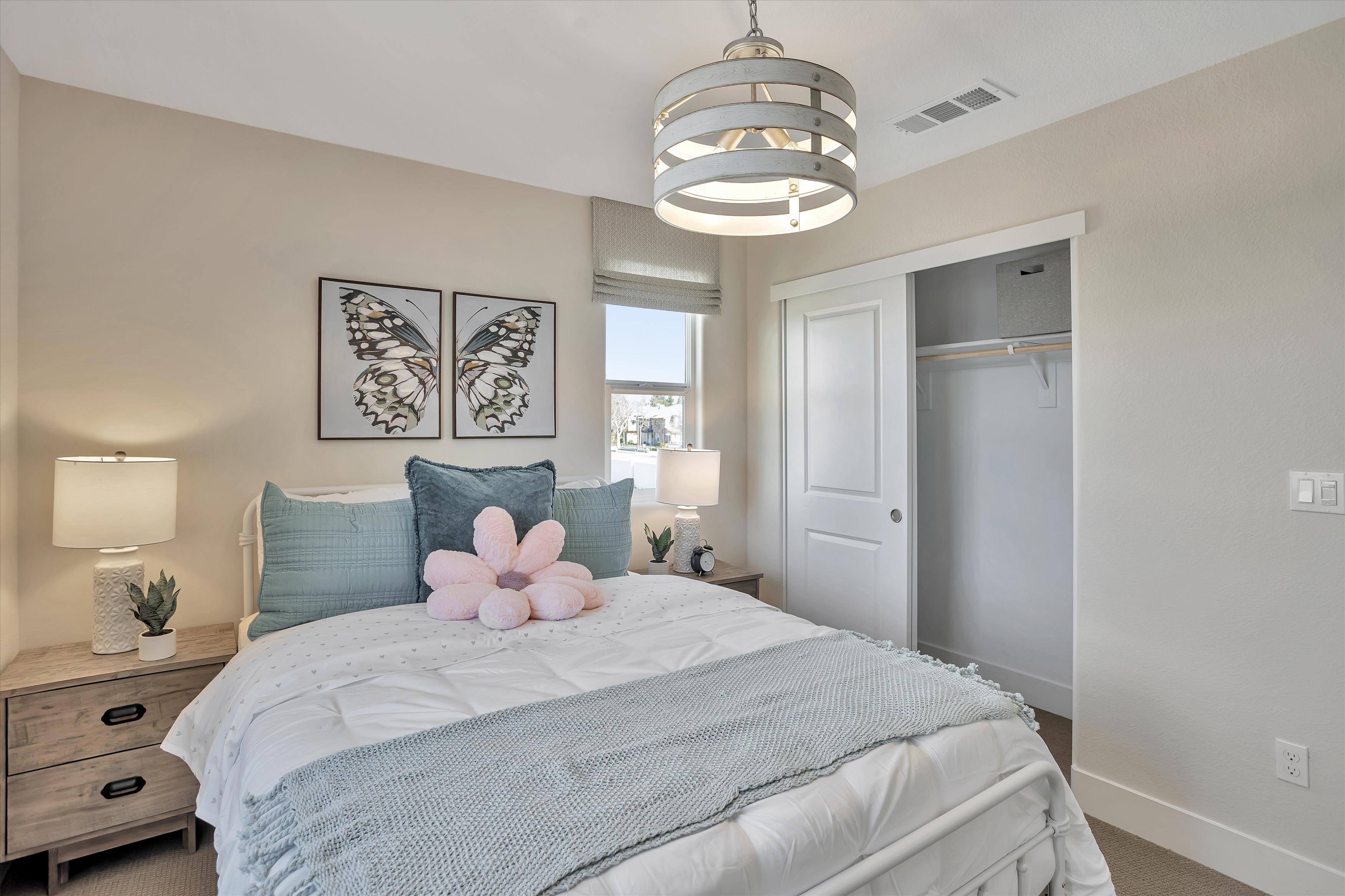 A bedroom with a bed and lamps.