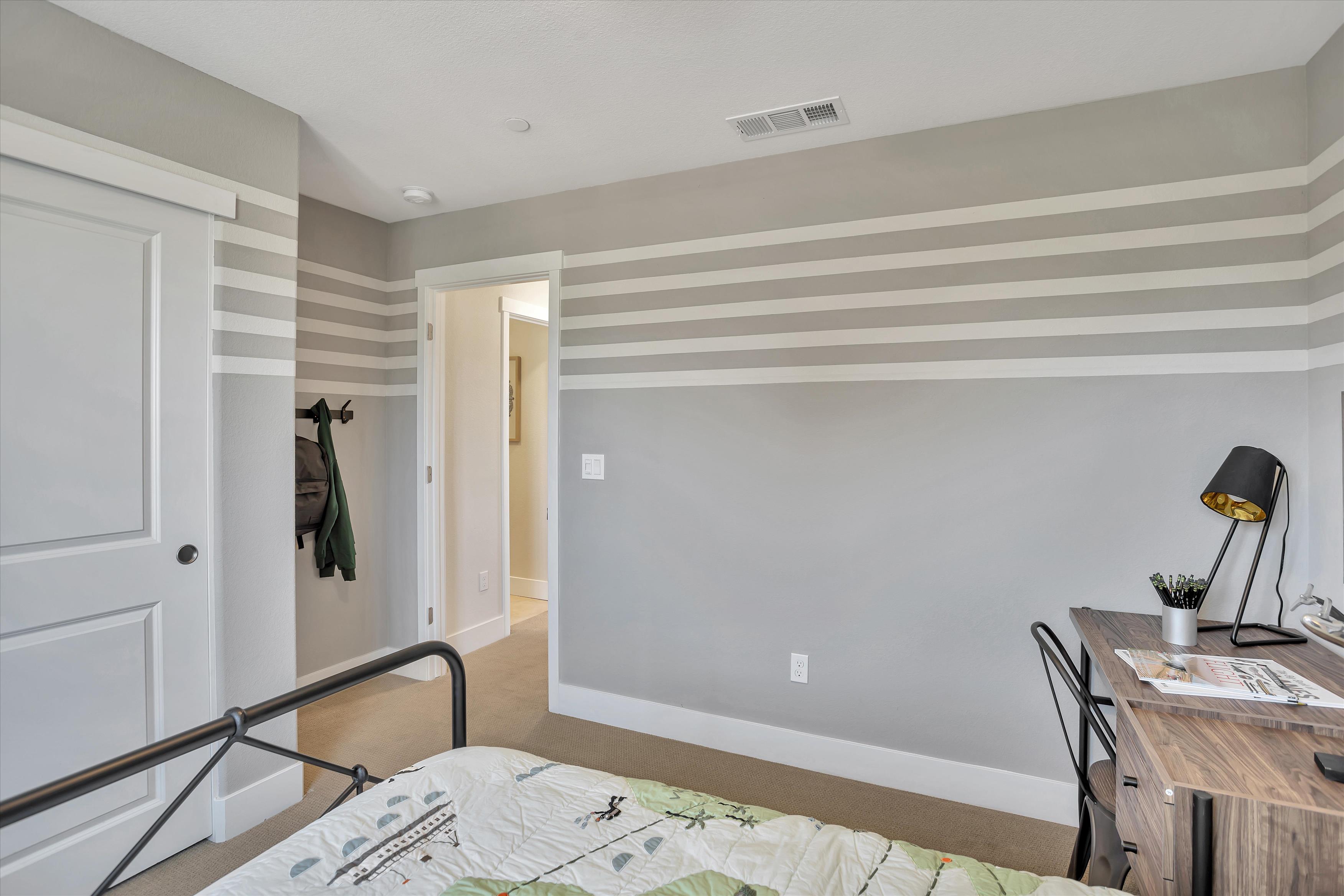 A bedroom with a bed and a desk.