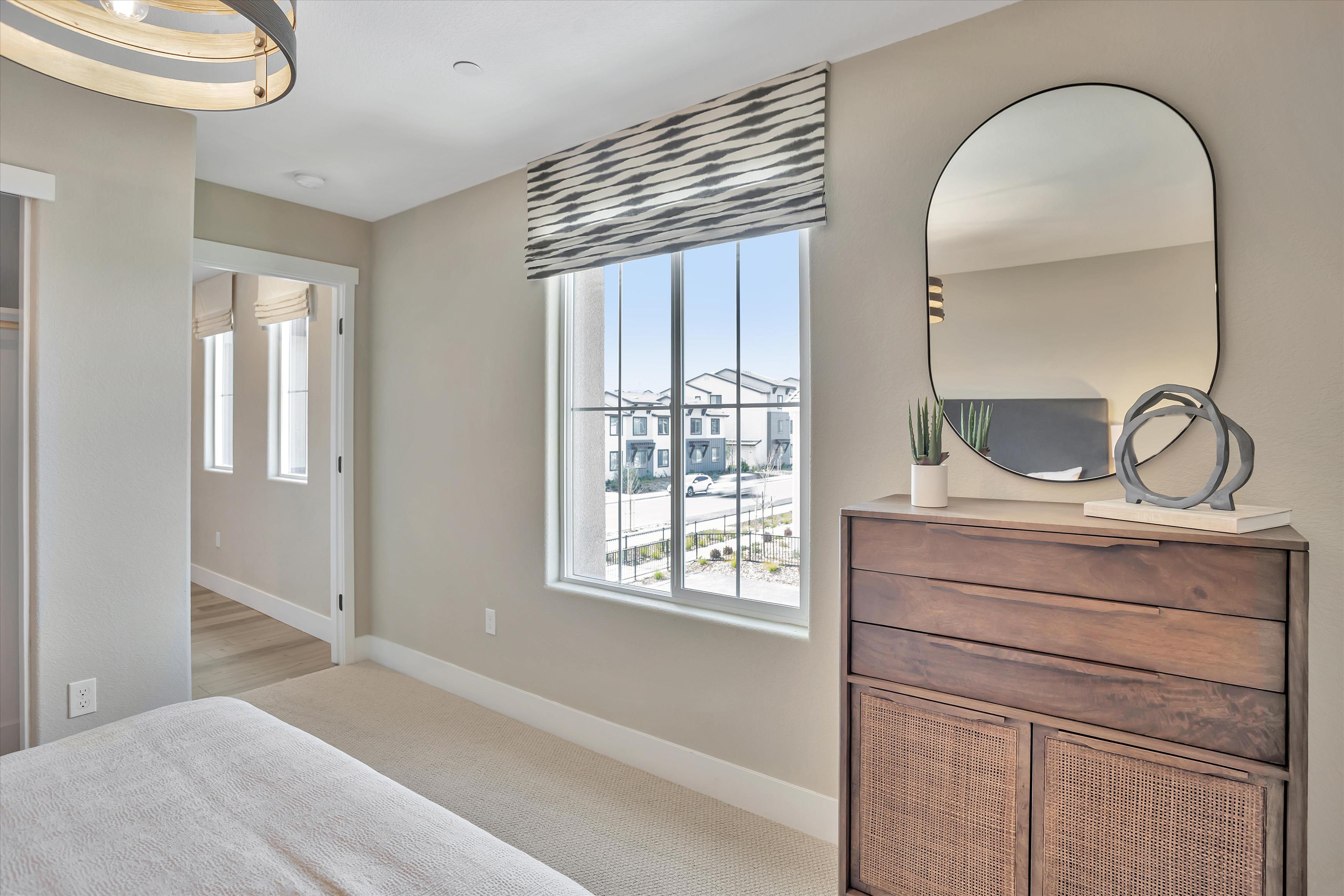 A room with a large mirror and a large window.