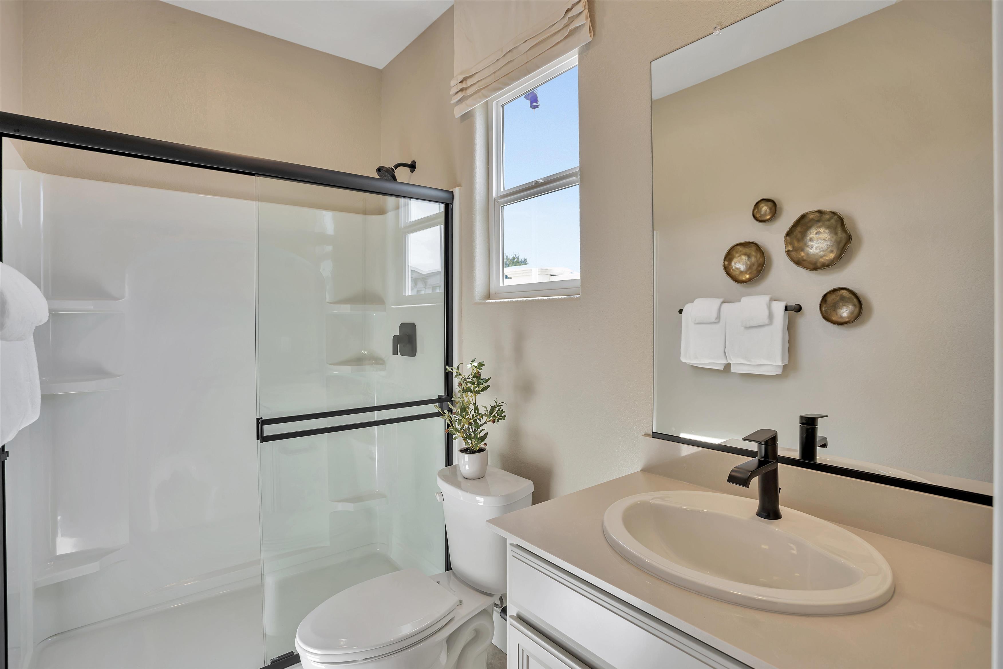 A bathroom with a sink toilet and shower.