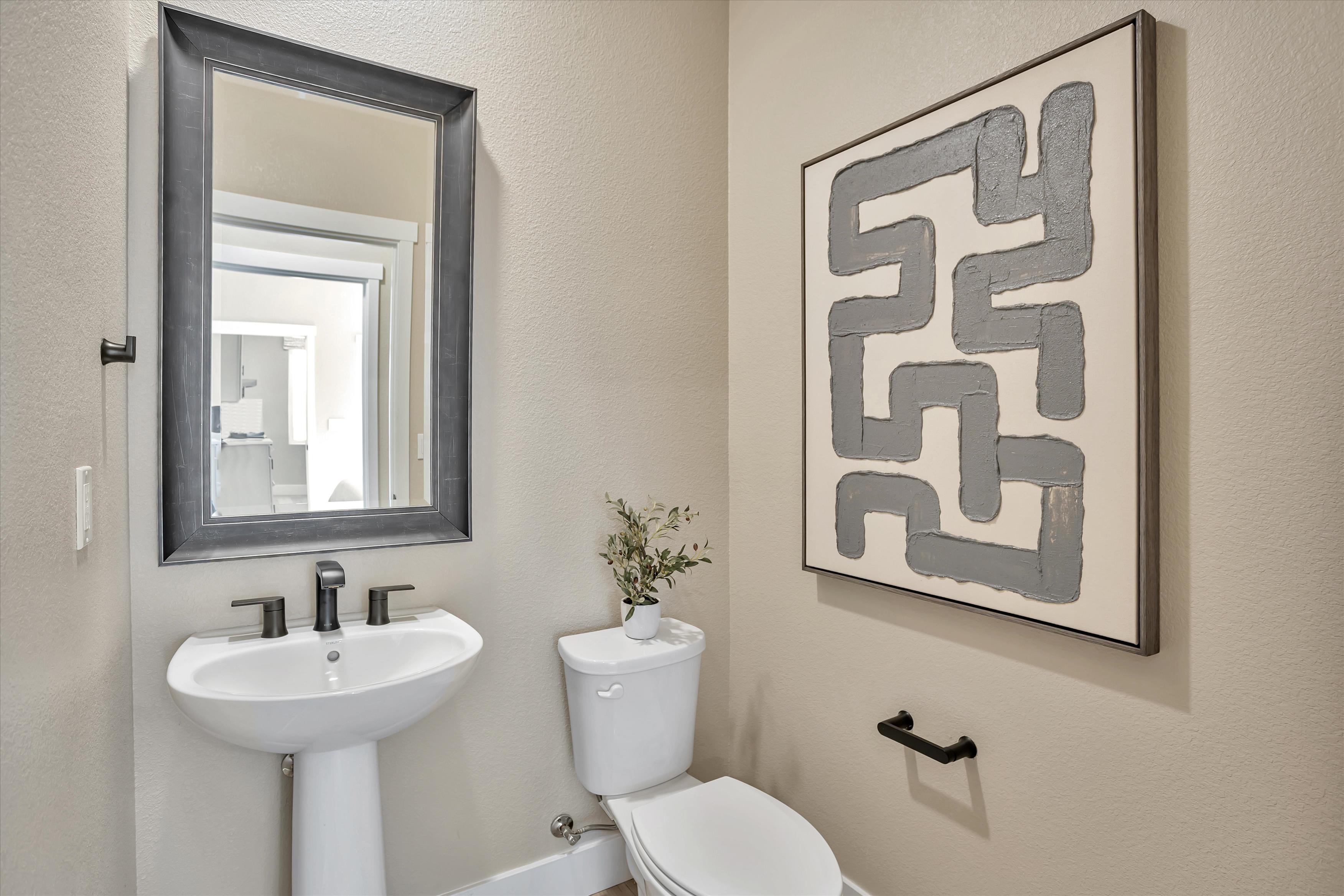 A bathroom with a picture on the wall.