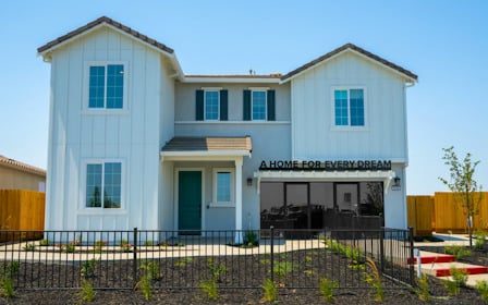 A white building with a black fence.