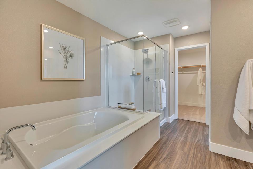 A bathroom with a tub and a mirror.